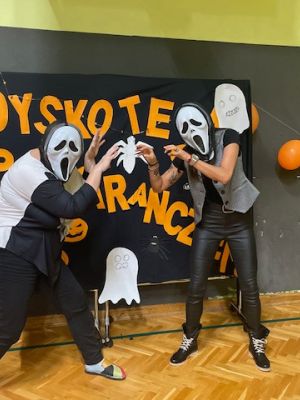 Uczestnicy dyskoteki robią sobie zdjęcie na ściance.