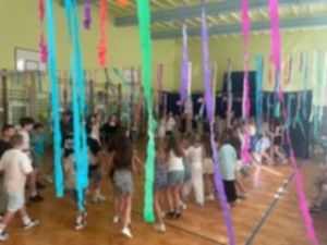Wszyscy uczniowie tańczący w kółku do letniej piosenki w rytmie disco. Wszyscy uczniowie tańczący w kółku do letniej piosenki w rytmie disco.