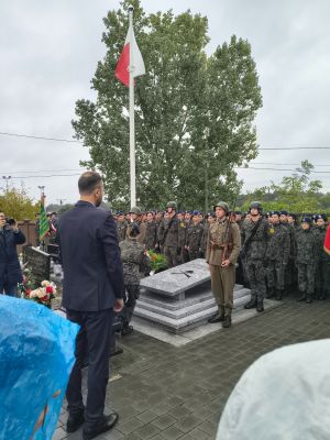 Burmistrz Strykowa Piotr Ślęzak składa kwiaty przy pomniku upamiętniającym poległych w 1939 roku.