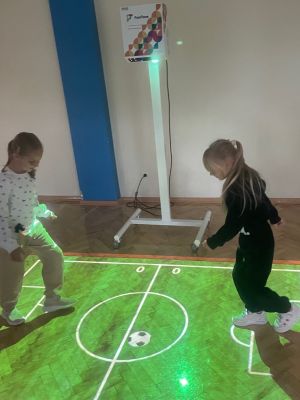 Uczniowie korzystają z gier dostępnych na podłodze interaktywnej podczas zajęć.