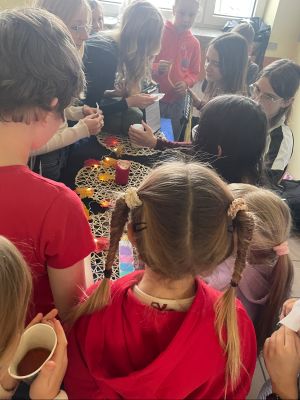 Uczniowie wr&oacute;żą z kolorowych karteczek. 