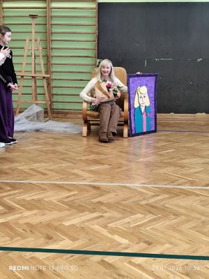 Nauczycielka siedzi na fotelu.