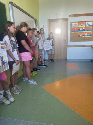 Czwartoklasiści prezentują plakaty swoim młodszym kolegom. 