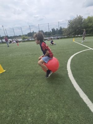 Uczeń pokonujący slalom na piłce. Uczeń pokonujący slalom na piłce.
