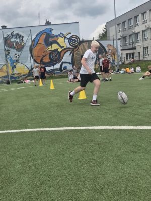 Uczeń pokonujący slalom z piłka. Uczeń pokonujący slalom z piłka.