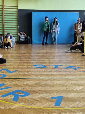 Nauczycielka prezentuje uczennicę, opowiadając o jej sukcesie. 