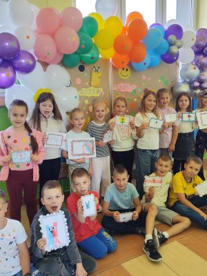 Uczniowie klasy 2a radośnie prezentują tw&oacute;rcze stroje, pełne własnoręcznie namalowanych i przyklejonych kropek.