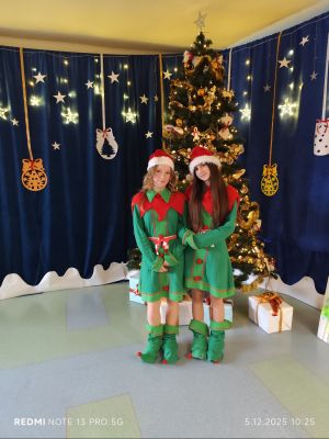 Uczennice na tle świątecznych dekoracji.