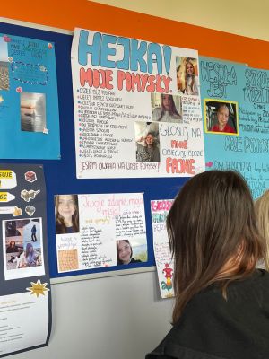 Uczniowie czytają informacje zawarte na plakatach wyborczych. 