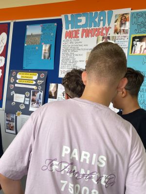 Uczniowie czytają informacje zawarte na plakatach wyborczych.