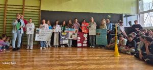 Przewodniczący klas prezentują swoje plakaty wyborcze podczas apelu. 