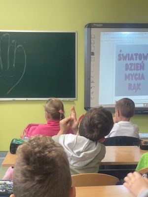 Pielęgniarka podczas prelekcji uczy uczni&oacute;w prawidłowego mycia rąk.