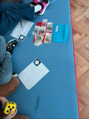 Uczniowie rzucają kostką i rozwiązują zadania ekonomiczne.
