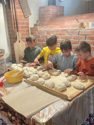 Uczniowie z zapałem wyrabiają ciasto na chleb
