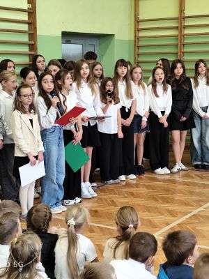 &Oacute;smoklasiści oraz piątoklasiści wykonują piosenkę pt. Wyśpiewać dziś chcemy wam życzenia.