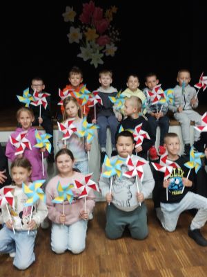 Wspólne zdjęcie pani bibliotekarki i uczniów z wykonanymi wiatraczkami Wspólne zdjęcie pani bibliotekarki i uczniów z wykonanymi wiatraczkami